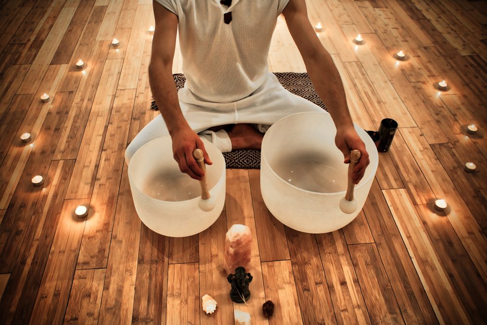 young,man,playing,crystal,bowls,as,part,of,a,meditative young,man,playing,crystal,bowls,as,part,of,a,meditative