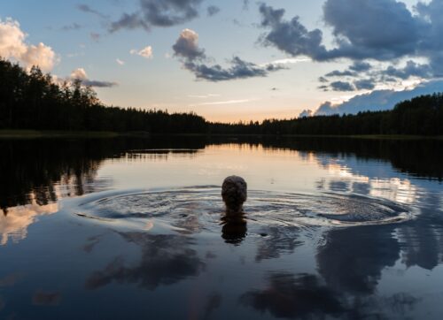 silhouette,of,a,girl,swimming,in,a,calm,lake,on