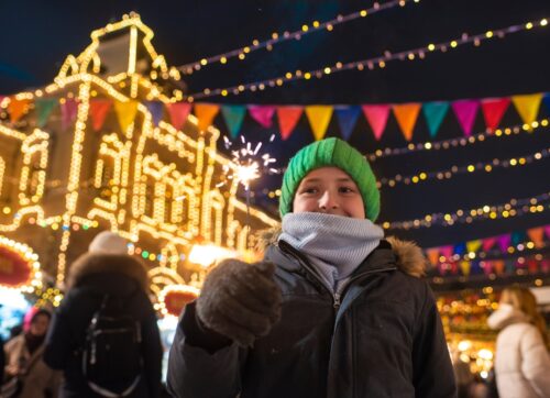 happy,boy,in,winter,clothes,holding,a,burning,sparkler,,having