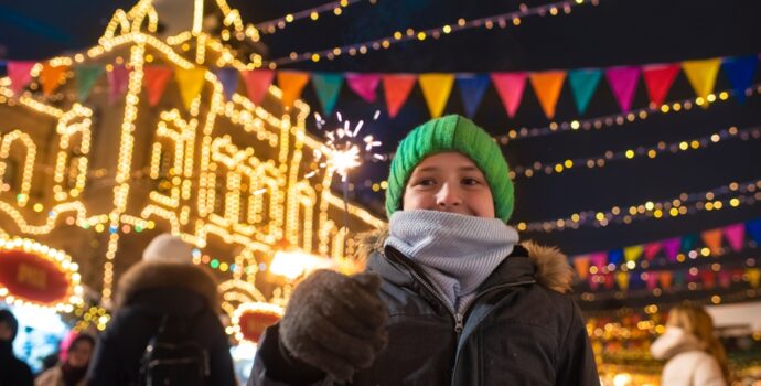 happy,boy,in,winter,clothes,holding,a,burning,sparkler,,having
