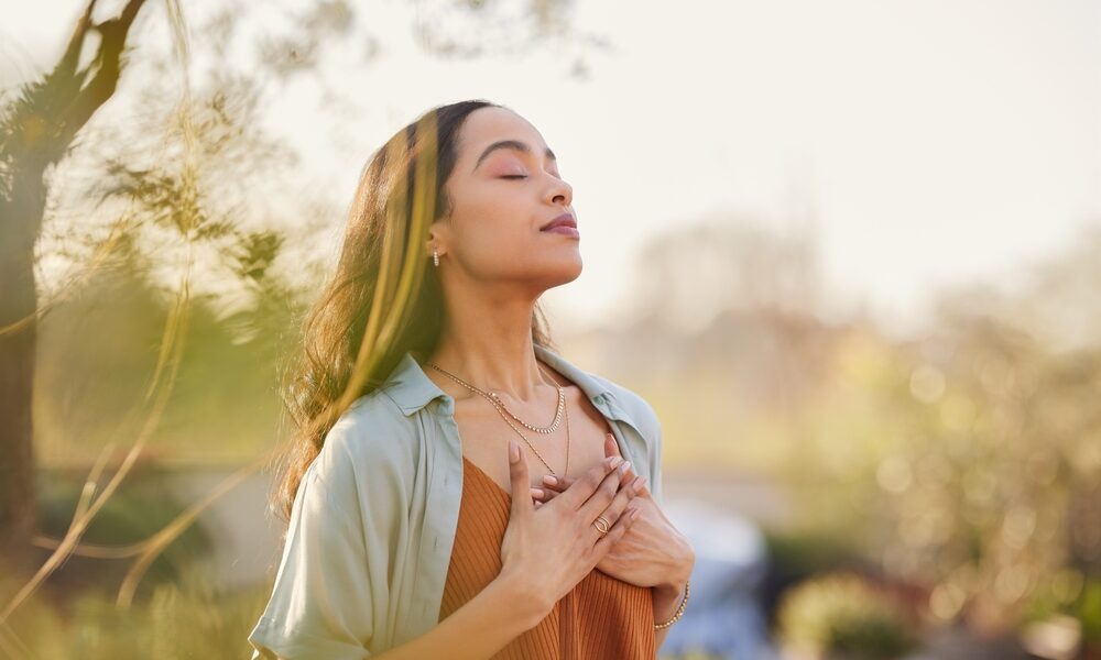 young,latin,woman,with,hand,on,chest,breathing,in,fresh