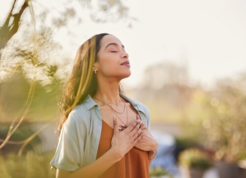 young,latin,woman,with,hand,on,chest,breathing,in,fresh