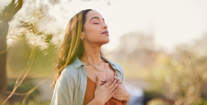 young,latin,woman,with,hand,on,chest,breathing,in,fresh young,latin,woman,with,hand,on,chest,breathing,in,fresh