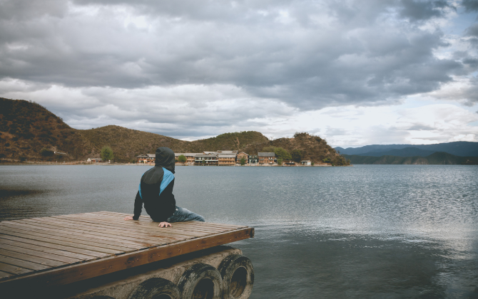 A person sitting or walking quietly in nature, surrounded by soft natural light, with a calm, contemplative feeling. The image should communicate the transition from mental noise to stillness and presence.