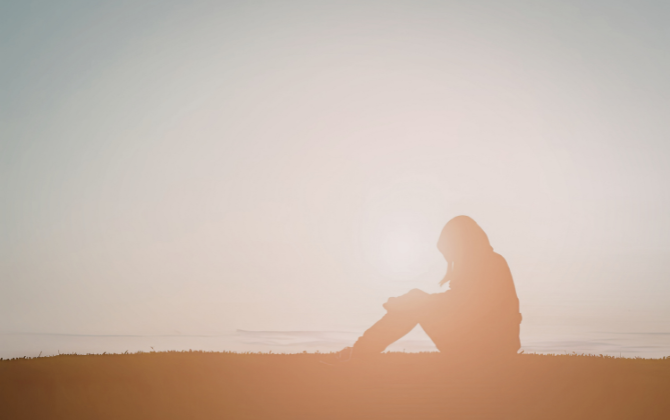 Pausing at a Mid-Thought Person sitting by the ocean in soft light, looking out in quiet thought