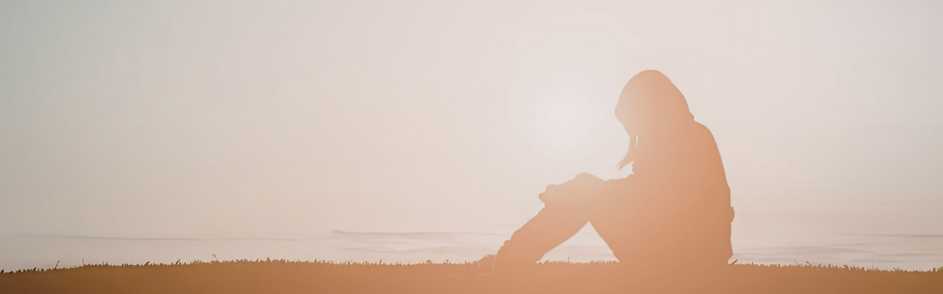 Pausing at a Mid-Thought Person sitting by a the ocean in soft light, looking out in quiet thought