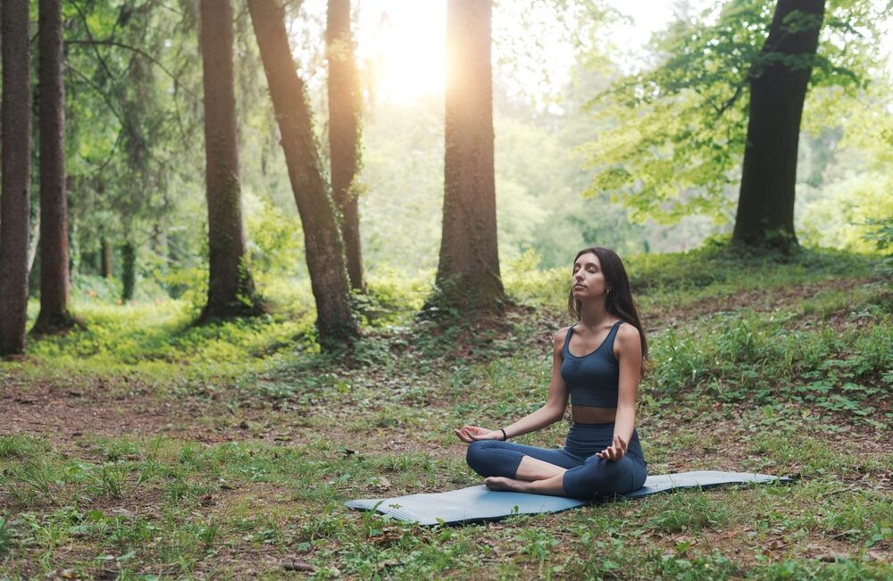 woman,sitting,in,the,lotus,position,outdoors,in,nature,,meditation